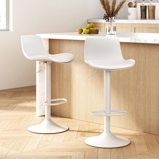 Elegant white leather swivel bar stools with soft padding, set against a warm timber kitchen backdrop.