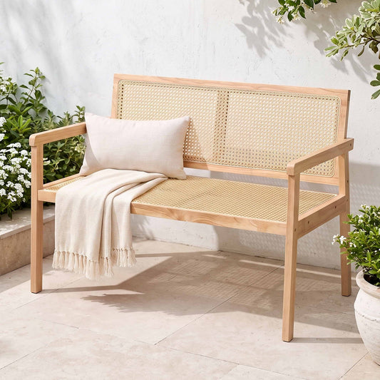 outdoor wooden garden bench with natural rubberwood frame and woven PVC seat, styled with decorative pillow and throw.