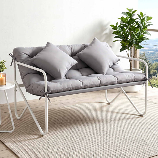 Comfortable outdoor garden bench with cushion, tufted grey fabric, metal frame, and decorative throw pillows.
