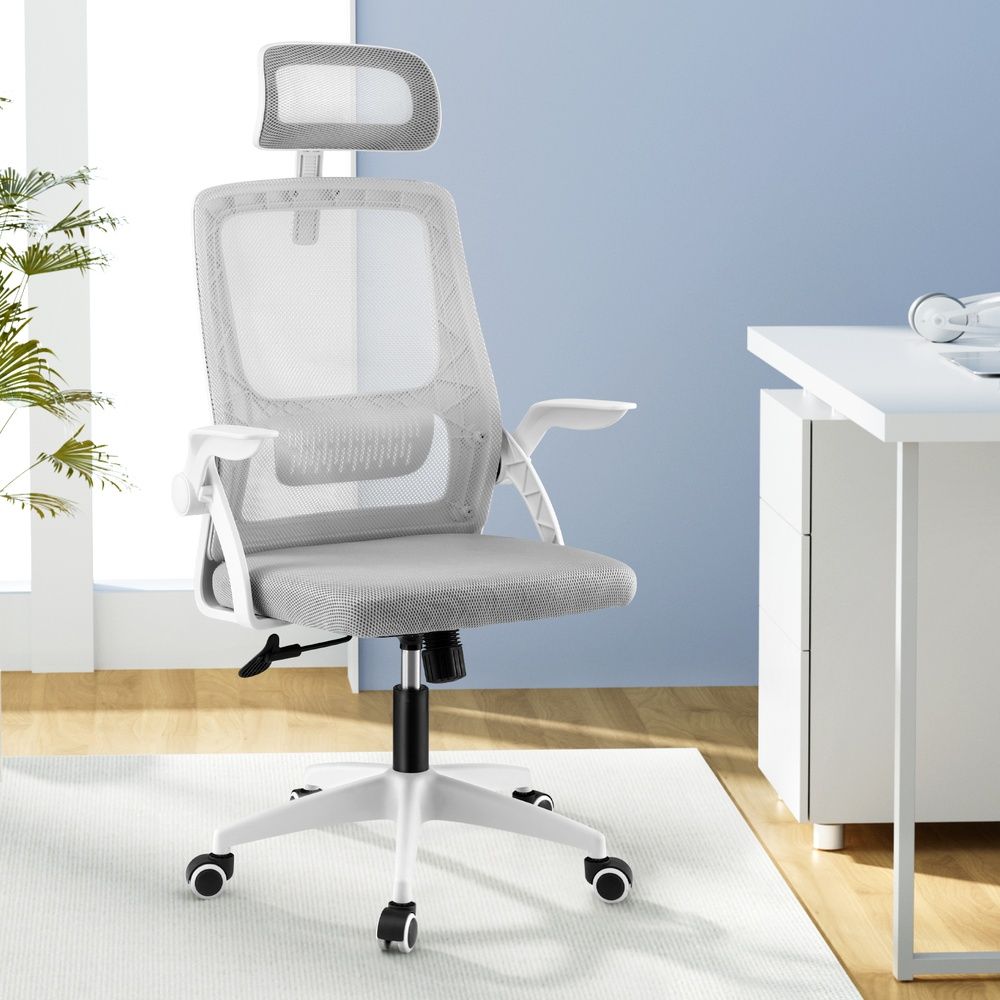 Grey mesh ergonomic office chair with adjustable headrest by The Willow Stone Collective, featuring a modern design and supportive back.