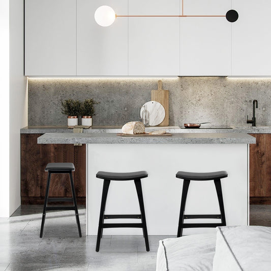 Padded wooden bar stool 65cm in black, enhancing a modern kitchen with sleek design and premium finishes.